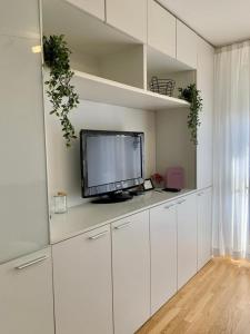 瓦拉日丁Apartment Nina的一间带电视和白色橱柜的客厅
