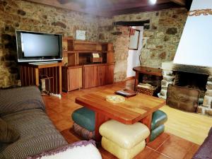 奥维多Casa Ferreira, Senda del Oso的客厅配有木桌和电视。