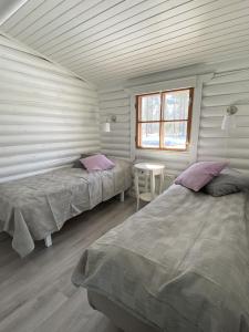 PålsböleBastöstugby stuga 17的一间卧室设有两张床、一张桌子和一个窗口
