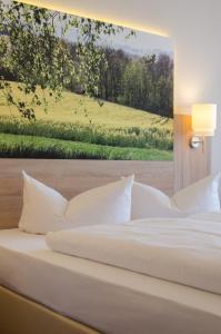 纽伦堡花园酒店的一张白色的床,墙上挂着一幅画