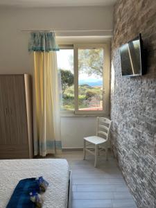 马达莱纳B&B Isola Mia的卧室配有床、椅子和窗户。