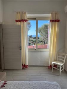 马达莱纳B&B Isola Mia的卧室设有门、椅子和窗户