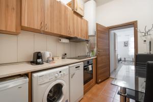 维也纳Ruhiges Apartment in 15 Min zum Zentrum的厨房配有洗衣机和烘干机