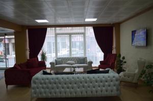 KoçyazıQuars Garden Hotel的客厅配有大型白色沙发和红色椅子
