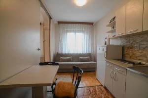 弗尔尼亚奇卡矿泉镇Apartman Marko的一间厨房,内设一张桌子和一张沙发