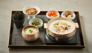 首尔Roynet Hotel Seoul Mapo的盘子,盘子上放着汤和碗