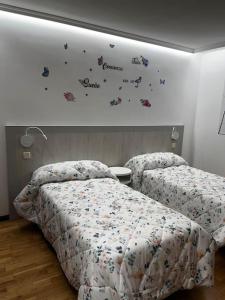 阿维拉El sitio de mi recreo Ávila的卧室内的两张床,墙上有蝴蝶