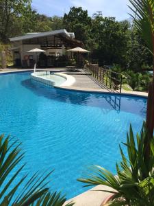 蓬塔雷纳斯Casa de playa con piscina y jacuzzi privado的一座蓝色的大型游泳池,其建筑背景为: