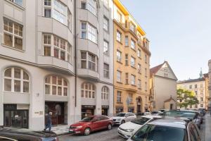 布拉格Old Town Square Luxury Apartment的街道上,有汽车停在建筑前
