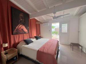 圣马丁岛Sweet Home SXM Baie Nettlé Pieds dans l'eau的一间卧室设有一张带红色墙壁的大床