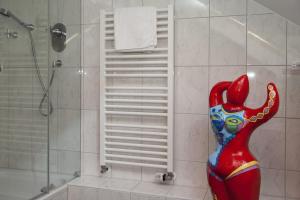 赖讷祖姆阿尔腾布龙嫩酒店的一间设有淋浴和女人雕像的浴室