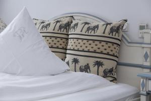 赖讷祖姆阿尔腾布龙嫩酒店的一张带白色床单和棕榈树枕头的床