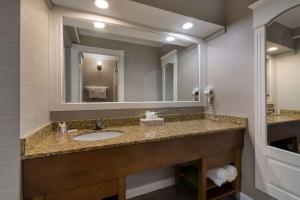 普拉茨堡Comfort Inn & Suites Plattsburgh - Morrisonville的一间带水槽和镜子的浴室