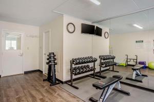 哈里斯堡Quality Inn Enola - Harrisburg的健身房,配有多种健身器材和墙上的时钟