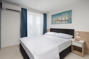 乌马格Garden Palace Resort的卧室设有一张白色大床和一扇窗户。