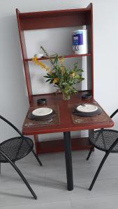 塞尔吉STUDIO TRES PROPRE de 18 m2的一张桌子,上面有两盘盘,花瓶