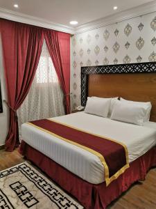 Farasanفندق ساسو سويت للوحدات المفروشه والفندقيه的一间卧室配有一张带红色窗帘的大床