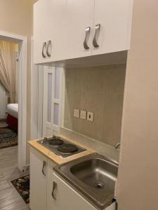 Farasanفندق ساسو سويت للوحدات المفروشه والفندقيه的厨房配有水槽和台面