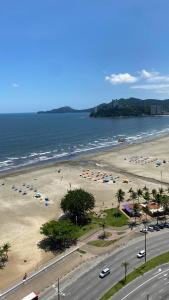 桑托斯Apartamento Frente ao Mar Santos的海滩上放着一把遮阳伞,大海