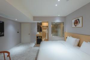 金海市Asherah Villa d' aqua Hotel的一间带白色大床的卧室和一间厨房