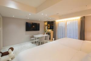 金海市Asherah Villa d' aqua Hotel的卧室配有白色的床和桌子
