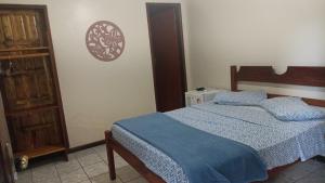 阿布拉奥Pousada Exuberante的一间卧室配有一张带蓝色棉被的床