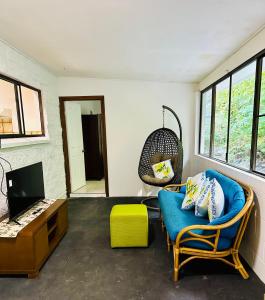 库兰达Botanica House Kuranda的客厅配有蓝色的沙发和电视