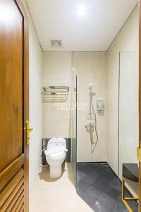 日惹KESATRIYAN JOGJA GUEST HOUSE的一间带卫生间和玻璃淋浴间的浴室