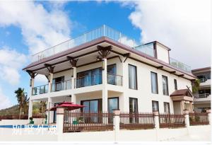 加拉班花蜜Spa酒店的带阳台和游泳池的白色建筑
