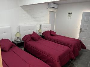 派桑杜Apart del Este Loft 6的客房内的3张床和红色床单