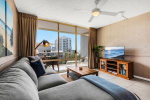 库鲁姆海滩冲浪舞公寓式酒店的带沙发和电视的客厅