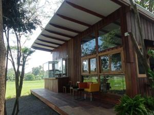 Chai NatBaan Tonjaeng Resort的房屋设有大窗户和木制甲板