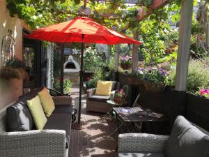 瓦纳卡滕培瓦纳卡住宿加早餐旅馆的一个带沙发和红伞的庭院