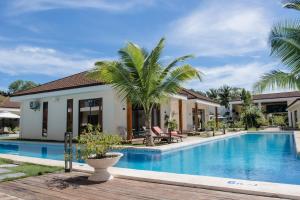 邦劳Amphitrite Resort的一座别墅,设有游泳池和棕榈树
