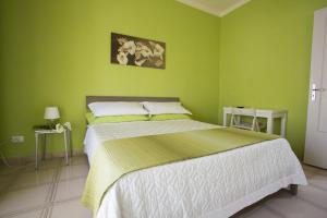 波托帕洛B&B Terra Nobile - Portopalo的绿色卧室配有大床