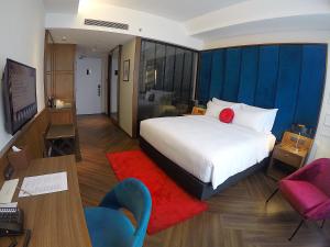 怡保唯裕酒店的酒店客房,配有一张床、一张桌子和椅子