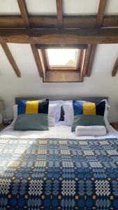 瓦伊河畔海伊Hay On Wye Welsh Townhouse in Hay centre的一间卧室配有一张带蓝色和黄色被子的床