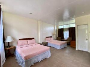 达古潘Rio Vista Bed and Breakfast的配有粉红色床单的客房内的两张床