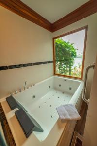 SauceRiosol Hotel Laguna Azul的一间带大浴缸和窗户的浴室