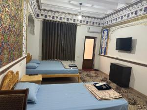 布哈拉TEMUR Hotel的客房设有两张床和一台平面电视。