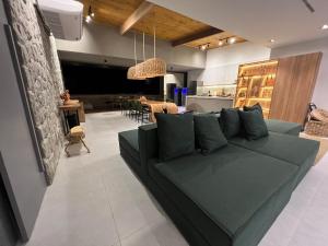 圣米格尔-杜斯米拉格里斯Kanui Mar (cobertura garden)的一间带绿色沙发的客厅和一间用餐室