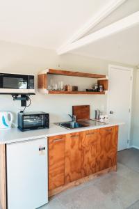 Kaipara FlatsThe Hen House的厨房配有水槽和微波炉