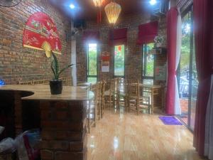 顺化Sunshine villa thuy bieu的配有桌椅的房间和砖墙