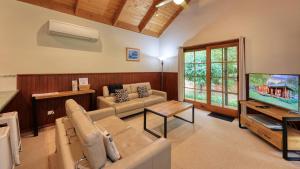 比奇沃斯Beechworth Cedar Cottages的带沙发和电视的客厅