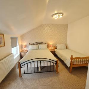 阿尔弗斯顿Ulverston Town Centre Flat (2 Bedrooms)的一间卧室配有两张床和两盏灯。