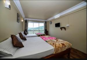 SonādaGhangri Sherpa Luxury Homestay, Darjiling的带大窗户的客房内的两张床