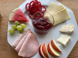 斯凯拜克Motel Rovli的盘子上的食物,包括奶酪水果和一碗果酱