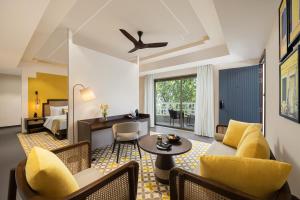 安君纳The Yellow House, Goa - IHCL SeleQtions的客厅配有沙发和桌子