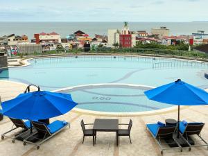 巴厘巴板巴厘巴板宜必思酒店的一个带椅子和遮阳伞的大型游泳池