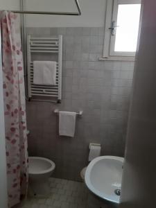 里米尼Hotel Migani的白色的浴室设有水槽和卫生间。